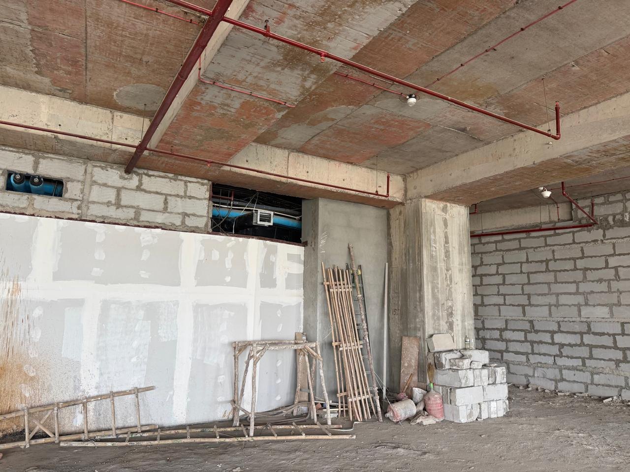 Raw site before fit-out: exposed structure and existing services · Saarthee Technology office, Magnum Global Park, Gurugram